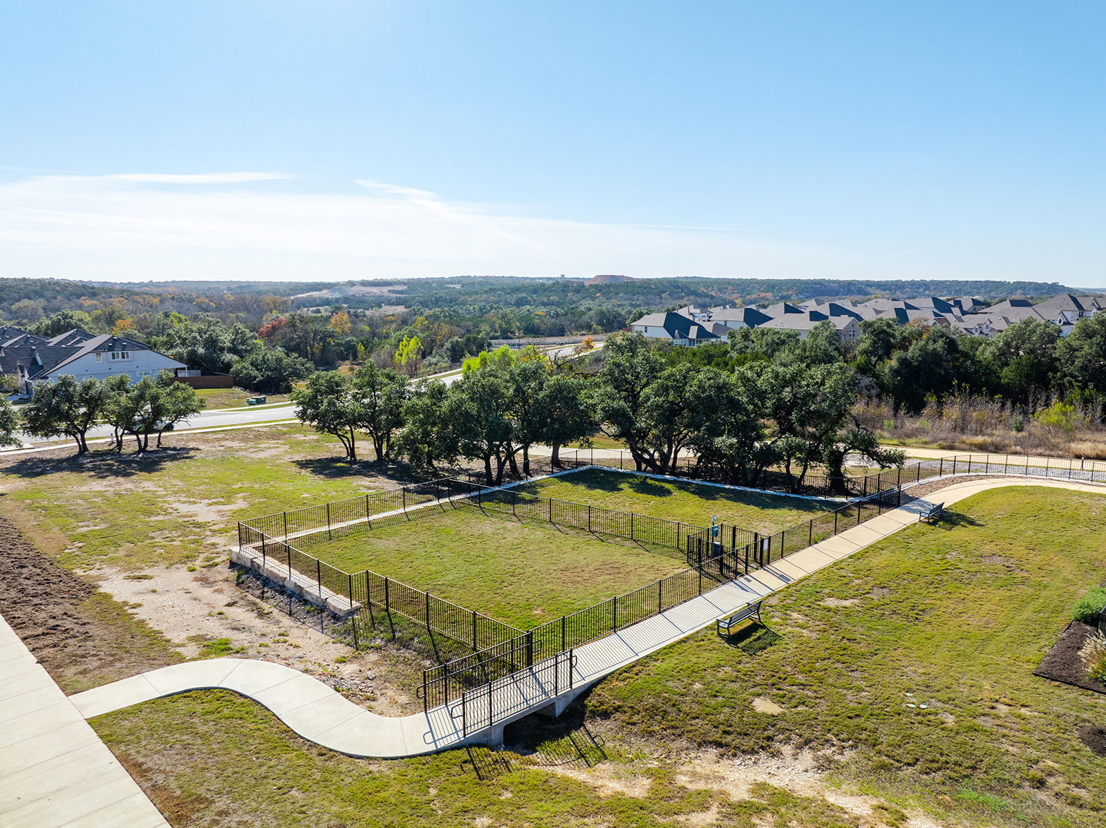 Community dog park with shaded oak trees, walking trails and Hill Country panorama